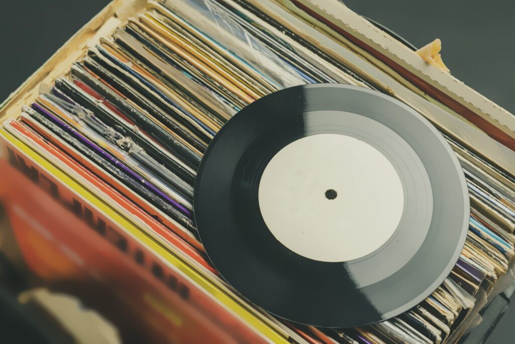 Vinyl record resting on a crate of record sleeves